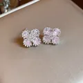 Primo piano di eleganti orecchini a lobo a fiore in argento e zircone con dettagli rosa - Rosa