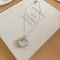 Détail d'un collier avec pendentif en cristal en forme de cœur sur un vieux livre. - Argent-Blanc
