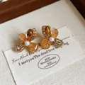 Detailed view of French vintage flower stud earrings with amber crystals and pearl center - Flower Style (HE32250) / 1 Pair Pack / Gold & Brown