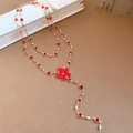 Detailed macro shot of red resin flower necklace featuring gold chain and rhinestones - Necklace / Gold-Red