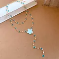 Close-up of elegant double-layered gold necklace with blue flower pendant and stones. - Necklace / Gold-Blue