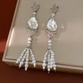Macro detail of vintage teardrop earrings featuring crystal stones and pearl tassels - White Water Drop Tassel Style / Silver