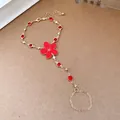 Detail of a red flower finger bracelet with gold chain and sparkling rhinestones - Ring and Bracelet Integrated Chain / Gold-Red