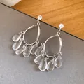 Close-up detail of elegant silver-toned drop earrings with clear resin teardrop tassels - Water Drop Tassel (HE34226) / Silver