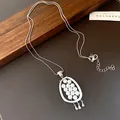 Close-up of retro silver oval necklace with pearl cluster on leather background - Silver
