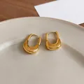 Close-up of 18K gold plated U-shaped earrings featuring a unique textured metallic finish - Ear Buckle / Gold
