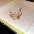 Primo piano di un anello a farfalla dorato con pietre di zirconia viola - Stile Farfalla (HR3438) / Aperto Regolabile / Viola