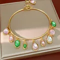 Detailed close-up of a gold-tone choker featuring multi-colored water drop rhinestone charms - Choker-Gold-Pink-Green