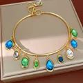 Close-up of gold-tone choker with vibrant teardrop and oval crystal charms - Choker-Blue-Green-Gray