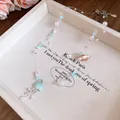 Detail shot of ocean-themed necklace featuring shell, pearl and jellyfish charms - Blue-Silver