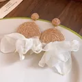 Detalle de pendientes de rafia con delicados lazos de gasa blanca - Amarillo