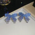 Detailed macro view of exquisite gradient blue rhinestone bow earrings in a luxury jewelry box - 18# Silver Earring Post - Blue