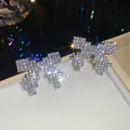 Close-up of sparkling pixel-style bow-knot stud earrings with full rhinestone pavé. - 19# Silver Pin - Silver