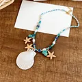 Gros plan d'un collier de perles d'été avec pendentif coquillage et breloques étoile de mer - Collier (Or/Coquillage Bleu)