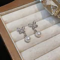 Close-up of elegant 18k gold plated butterfly earrings with white pearls and zircons. - Butterfly Pearl Drop Style (Silver Post) / Silver