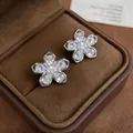 Macro view of elegant silver flower-shaped zircon clip-on earrings inside a box - Ear Cuff (Pair) / Silver