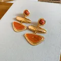 Detailed macro shot of vintage geometric triangle earrings with orange stones and gold finish - Silver Post - Orange Gold