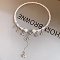 Close-up view of the intricate star charms and tassel detail on the pearl choker necklace - Star Tassel Style