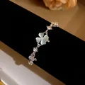 Detail view of silver clover bracelet featuring cat eye stone and sparkling zircons - Green