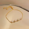 Detailed macro view of an 18k gold-plated bamboo bracelet featuring shimmering zircon accents. - Bamboo Slider Style / Gold