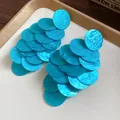 Detailed view of blue acrylic marbled circular disc cascading tassel earrings. - Stud Earrings / Blue
