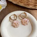 Dettaglio degli orecchini a cerchio con fiori rosa in stile francese e perle eleganti - Orecchini a Cerchio Floreali / Oro Rosa