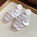 Close-up of white marbled acrylic layered circle tassel earrings on tray - Stud Earrings / White