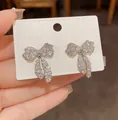 Primo piano di orecchini a fiocco in argento con zirconi cubici su scheda display - Stile Fiocco (HE32370-1) / Argento