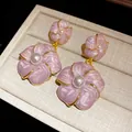 Close-up of French vintage pink flower earrings with pearl centers and gold trim. - Silver Earring Post Style / Purple
