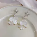 Vue détaillée de boucles d'oreilles étoile de mer avec pétales de fleurs en nacre - Blanc