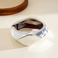 Close-up view of a minimalist silver geometric faceted bangle with a hinged opening - Bracelet - Silver