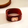 Macro detailed view of an amber resin square bangle inlaid with a large peach gemstone - Bangle-Coffee