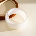 Detailed close-up of a white resin bangle with shimmering finish on a wooden display - White Iridescent Bangle