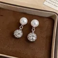 Primo piano di orecchini di perle in stile francese con ciondoli a sfera di cristallo - Argento