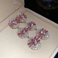 Close-up detail of luxury pink rhinestone oval tassel earrings in a velvet box. - Western Fashion Tassel Style / Gold-Pink