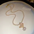 Vue détaillée d'un élégant collier pendentif papillon avec cristaux roses et perles blanches. - Collier (Or)