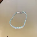 Detailed macro view of a tennis bracelet with blue and clear stones on a mirror - Simple Luxury Style