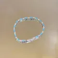 Detailed view of a light blue crystal bracelet with silver metal and sparkly stones - Emerald Cut Gem Style