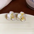 Detailed macro shot of elegant silver flower stud earrings with yellow drip oil and zircon - Yellow