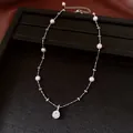Primo piano di collana di perle con ciondolo in zircone su un vassoio nero opaco - Stile Zirconia Tonda (4#) / Argento-Bianco