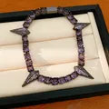 Close-up view of a purple zircon bracelet with spike charms in a professional jewelry tray - Gunmetal - Purple