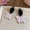 Détail de boucles d'oreilles papillon rétro en bois noir et résine rose perle - Papillon Perle Grain de Bois Ovale / Tige en argent 925 / Noir/Rose