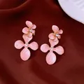 Détail de boucles d'oreilles fleurs en émail rose élégantes avec cristaux brillants - Or-Rose