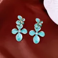 Détail de boucles d'oreilles fleurs en émail bleu vintage élégantes avec des cristaux. - Or-Bleu