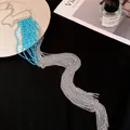 Vue détaillée du collier à pampilles en chaîne argentée avec perles bleues sur fond noir - Bleu