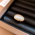 Close-up of a minimalist 18k gold plated open ring with a rutilated quartz stone - Oval Style (HR3659) / Gold