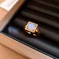Macro detail of 18k gold plated square ring with glowing blue round gemstone - Round Style (HR3660) / Gold