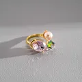 Detailed close-up view of the luxury open ring with pink oval crystal and faux pearl accent - Gold-Pink