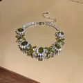 Dettaglio macro del bracciale a fiori in zircone verde oliva con finitura argento lucido - Argento-Verde