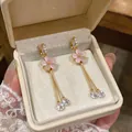 Elegant close-up of pink enamel flower tassel ear clips with cubic zirconia gems. - Pink Flower Tassel Ear Clips (HE32924) / 1 Pair Pack / Gold